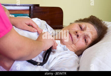 Bild von eine kranke ältere Frau zu Hause mit ihrem Betreuer Stockfoto