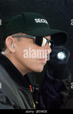 Nahaufnahme von einem Wachmann mit seiner Taschenlampe suchen. Stockfoto