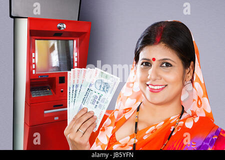 1 Ländliche Frau Geldautomaten Bargeld beziehen mit indischen Banknoten Stockfoto