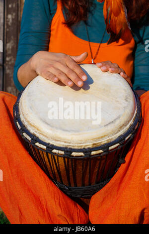 Junge Dame Schlagzeuger mit ihrer Djembe-Trommel. Stockfoto