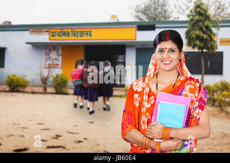 Indischen ländlichen Frau Lehrerin Holding Buch stehen in der Dorfschule. Bildung Konzept Stockfoto