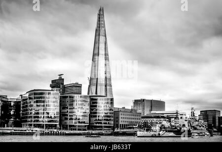 London, März 2017, Vereinigtes Königreich: Blick vom Nordufer der Themse historischen HMS Belfast Cruiser verankert Themse Wolkenkratzer Shard im Hintergrund an einem bewölkten Märztag in London Stockfoto