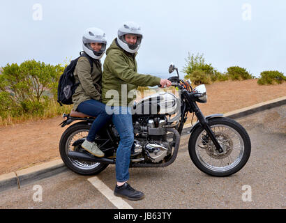 Mann und Frau auf einer Triumph Motorcyle im Regen und Nebel von San Francisco, Kalifornien Stockfoto