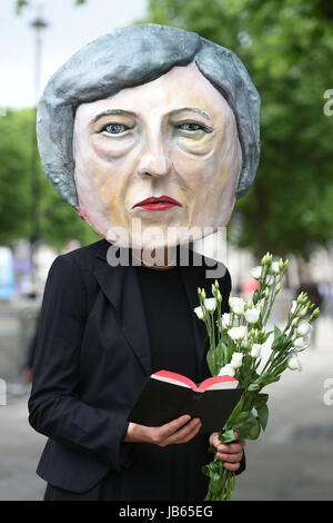 Ein Protest organisiert durch die globale Kampagne Bewegung Avaaz auf Whitehall in London, einer lebensgroßen Riesen-köpfigen Marionette von Theresa Mai verlassen Blumen an einen Grabstein mit der Aufschrift schwer Brexit RIP, wie ihre Zukunft als Premierminister und Führer der konservativen offen in Frage gestellt wurde, nachdem ihre Entscheidung, eine Snap-Wahl katastrophal zu halten ging nach hinten los. Stockfoto