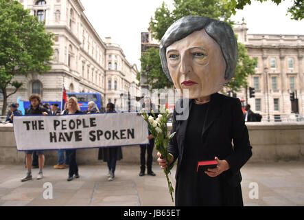 Ein Protest organisiert durch die globale Kampagne Bewegung Avaaz auf Whitehall in London, einer lebensgroßen Riesen-köpfigen Marionette von Theresa Mai verlassen Blumen an einen Grabstein mit der Aufschrift schwer Brexit RIP, wie ihre Zukunft als Premierminister und Führer der konservativen offen in Frage gestellt wurde, nachdem ihre Entscheidung, eine Snap-Wahl katastrophal zu halten ging nach hinten los. Stockfoto