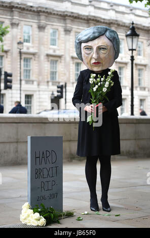 Ein Protest organisiert durch die globale Kampagne Bewegung Avaaz auf Whitehall in London, einer lebensgroßen Riesen-köpfigen Marionette von Theresa Mai verlassen Blumen an einen Grabstein mit der Aufschrift schwer Brexit RIP, wie ihre Zukunft als Premierminister und Führer der konservativen offen in Frage gestellt wurde, nachdem ihre Entscheidung, eine Snap-Wahl katastrophal zu halten ging nach hinten los. Stockfoto