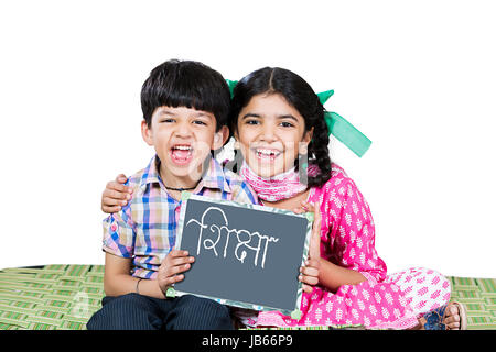 2 Indischen ländlichen Kinder Jungen und Mädchen sitzen auf Babybett zusammen und zeigen Schiefer Vorstand Ausbildung Lernen Stockfoto