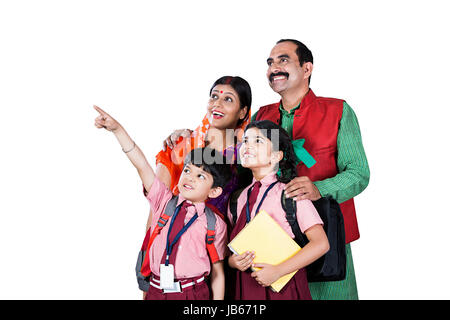 Indischen ländlichen Familie - Eltern und 2 Kinder zusammen etwas zeigen. Kinder und Schüler Stockfoto