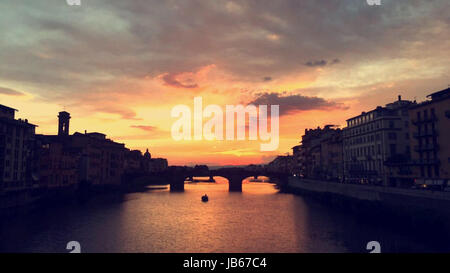 Sonnenuntergang an der Riviera über die Brücke mit dem Wasser spiegelt den Himmel in Florenz, Italien Stockfoto