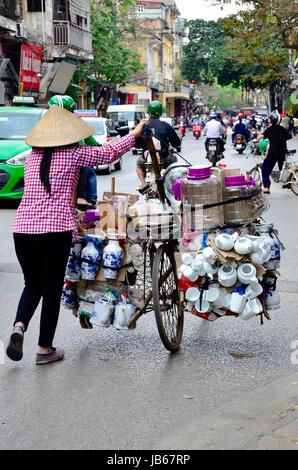 Eine Dame, die Transport von Geschirr in einem Push-Motorrad in Hanoi, Vietnam Stockfoto