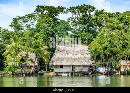 Rio Dulce, Guatemala - September 1, 2016: Holzhäuser auf Stelzen mit palm leaf Dächer am Ufer des Rio Dulce, Guatemala, Mittelamerika Stockfoto