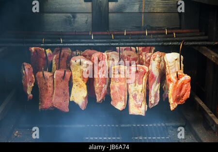 Schinken, Wurst in eine hausgemachte Räucherkammer hängenden geräucherten Speck für Räucherei Stockfoto