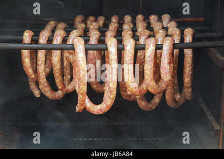 Geräucherte Würste hängen in der Räucherei, geräucherte Würste auf traditionelle Art und Weise. Tiefenschärfe und flachen Dof. Stockfoto