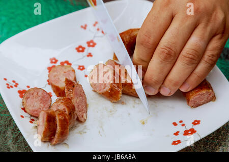 Mann schneiden Wurst schneiden Würstchen Geschirr, Mann, Fleisch, Metall, Ernährung person Stockfoto