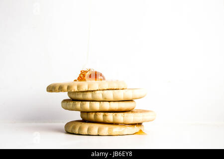 Ein runder Weizen Cookie auf einem Freund mit einer Folie Honig tropft aus der Spitze. Foto für Ihr design Stockfoto