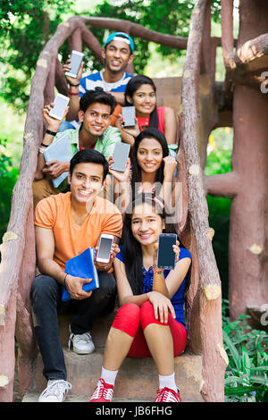 Gruppe College Jungen und Mädchen sitzen Holztreppen und Handy in Park Stockfoto