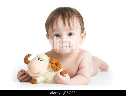 Baby Boy auf Bauch liegend mit Lamm-Spielzeug Stockfoto