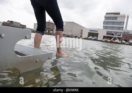 Münster, Deutschland. 9. Juni 2017. Ein Besucher geht auf die Installation «On Water» von Ayse Erkmen in Münster, 9. Juni 2017. Die Installation ist ein Laufsteg unter Wasser die beiden Ufer verbindet. Besucher können drüber gehen. Die Eröffnung der fünften Ausgabe des Zehn-Jahres-Dur-Ausstellung "Skulptur Projekte" findet am 10. Juni 2017. Seine Ableger ist der 60 Kilometer entfernten Marl. Foto: Friso Gentsch/Dpa/Alamy Live News Stockfoto