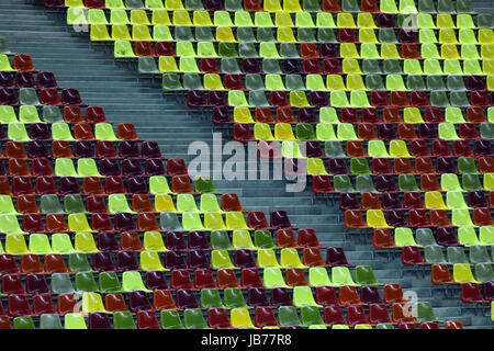 Leere Sitzreihen in verschiedenen Farben in einem Stadion Stockfoto