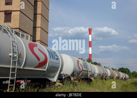 Belgrad, Serbien - 3. Juni 2017: Tank Wagen Zug von Nafta Industria Srbije, vorbei an einem Fabrikschornstein in ein Industriegebiet der Kopf Stockfoto