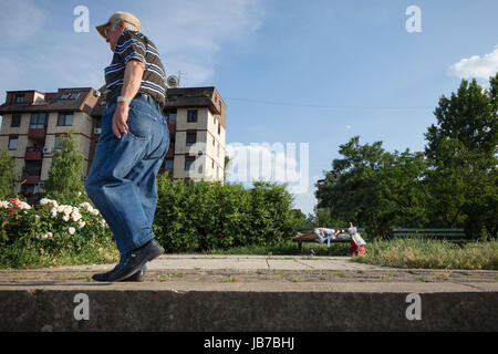 Belgrad, Serbien - 3. Juni 2017: Alter Mann zu Fuß in der Nähe von einem senior Frau schläft auf einer Bank, im Bezirk von Doni Dorcol, Belgrad-Bild von einem ol Stockfoto