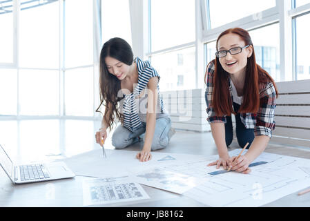 Fröhliche junge Ingenieure, die an einem Projekt arbeiten Stockfoto