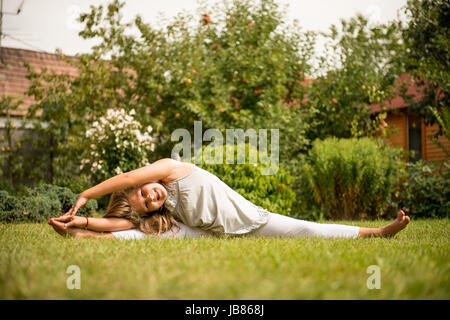 Sport auf Rasen - lächelnd kleines Kind trainieren im Freien im Garten Stockfoto