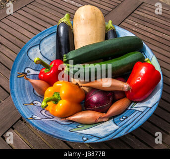 Noch immer leben handgemachte Keramik Schüssel mit frischem Gemüse auf Holz Outdoor Picknick Tisch Stockfoto