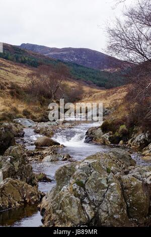 Blick nach Westen bis ins Tal Glen Sannox aus einer Mitte Stream Exposition von Kissen Basalt. Isle of Arran, Schottland. April 2017. Stockfoto