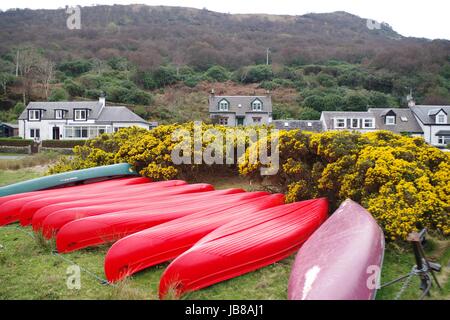 Kanus und Hütten. Lochranza, North Arran, Schottland, Großbritannien. April 2017. Stockfoto