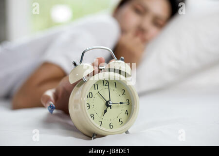 Asiatische Frau glücklich aufwachen und das Ausschalten der Wecker einen guten Tag Stockfoto