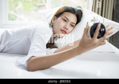 Asiatische Frau glücklich aufwachen und das Ausschalten der Wecker einen guten Tag Stockfoto