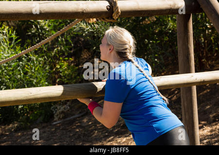 Frau auf outdoor-Ausrüstung beim Hindernis-Parcours-Training im Boot Camp Training Stockfoto