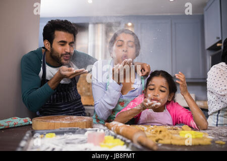 Spielerische Familie weht Mehl in der Küche zu Hause Stockfoto