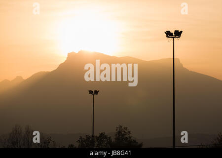 Telegrafenmasten Kabel in den Sonnenuntergang mit Bergen im Hintergrund Stockfoto