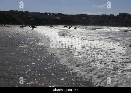 Ansicht der Schwimmer und Surfer Silhouetten auf Fistral Beach, Newquay in Cornwall an Sommertagen Stockfoto