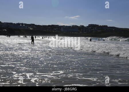 Ansicht der Schwimmer und Surfer Silhouetten auf Fistral Beach, Newquay in Cornwall an Sommertagen Stockfoto