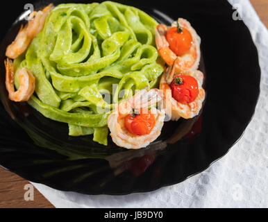 Spinat-Nudeln mit Garnelen und Kirschtomaten Nahaufnahme Stockfoto