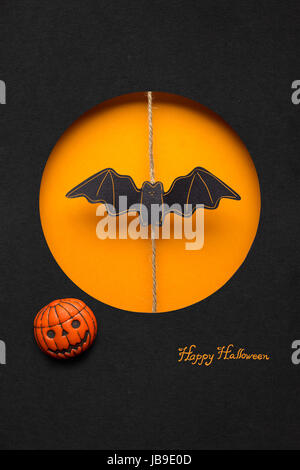 Kreative Halloween Konzept Foto einer Fledermaus Papier auf orange schwarzen Hintergrund gemacht. Stockfoto