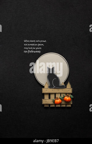 Kreative Halloween Konzept Foto einer Katze auf ein Zaun aus Papier auf schwarzem Hintergrund. Stockfoto