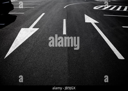 Pfeil-Symbol als Straßenmarkierungen auf einer Straße Stockfoto