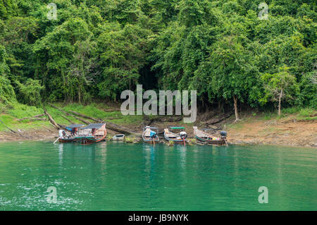 Longtail-Boote auf dem smaragdgrünen Wasser des Cheow Lan See schwimmen Stockfoto