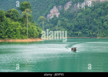 Longtail-Boot auf dem smaragdgrünen Wasser des Cheow Lan Lake Stockfoto