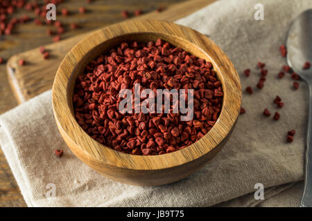 Rohe rote Bio Annatto Samen in eine Schüssel geben Stockfoto