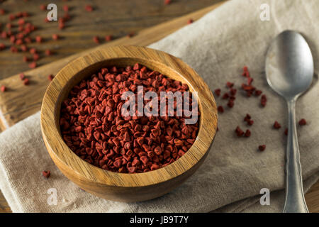 Rohe rote Bio Annatto Samen in eine Schüssel geben Stockfoto