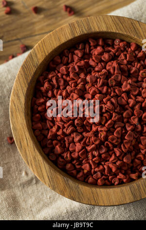 Rohe rote Bio Annatto Samen in eine Schüssel geben Stockfoto