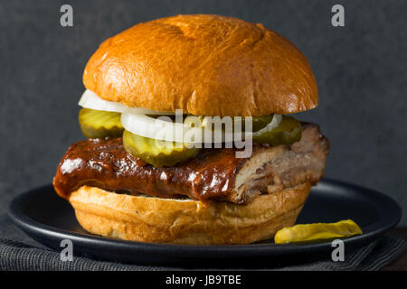 Hausgemachten geräucherten BBQ Rib Sandwich mit Gurken und Zwiebeln Stockfoto