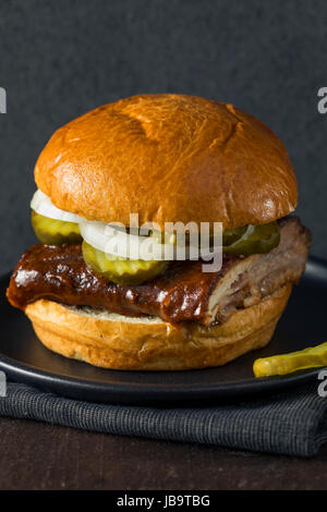 Hausgemachten geräucherten BBQ Rib Sandwich mit Gurken und Zwiebeln Stockfoto