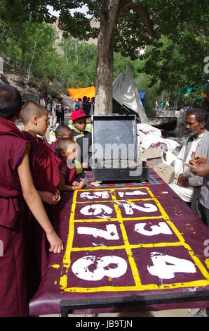 Junge buddhistische Mönche spielen Roulette während der Hemis Festival in Hemis Kloster in Ladakh, Indien Stockfoto