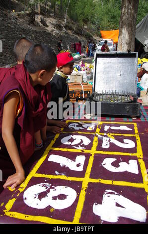 Junge buddhistische Mönche spielen Roulette während der Hemis Festival in Hemis Kloster in Ladakh, Indien Stockfoto